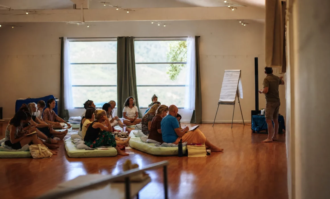Groupe d’adultes réuni sur des coussins pendant une formation au toucher