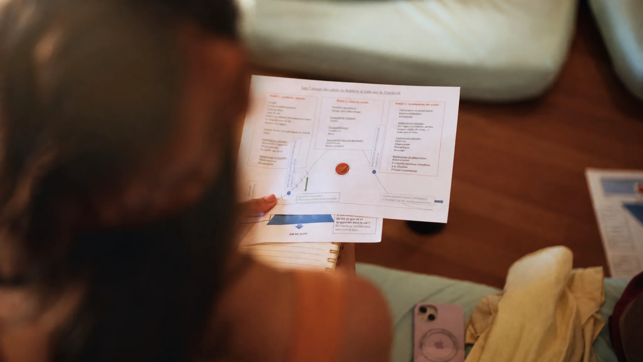 Personne consultant un document imprimé posé sur une surface en bois